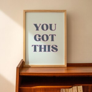 May include: A framed print with a light blue background and the text "YOU GOT THIS" in dark blue letters with a pink outline.