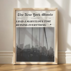 Op de afbeelding: Een zwart-witfoto van een brug over een skyline van een stad. De foto is ingelijst in een houten lijst. De kop van de krant luidt "The New York Minute" en de onderkop luidt "Ik had een geweldige tijd om alles te verpesten."
