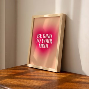 May include: A framed print with a pink and orange gradient background. The text "BE KIND TO YOUR MIND" is printed in white on the print.