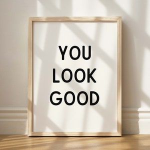 May include: A framed print with the text "YOU LOOK GOOD" in black lettering on a white background.