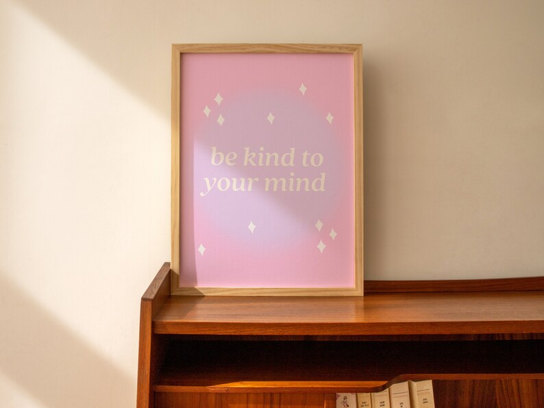 May include: A framed print with a pink and purple ombre background and white stars. The print says "be kind to your mind".