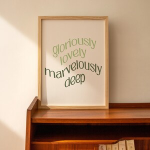 May include: A framed print with the words "gloriously lovely marvelously deep" in green text on a white background.
