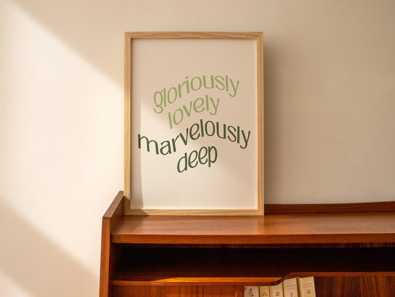 May include: A framed print with the words "gloriously lovely marvelously deep" in green text on a white background.