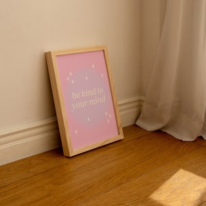 May include: A framed print with a pink and purple ombre background and white text that reads "be kind to your mind".