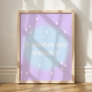 Puede incluir: Una impresi&oacute;n enmarcada con un fondo degradado azul claro y morado. La impresi&oacute;n presenta formas de diamantes blancos y el texto "it makes me wonder".