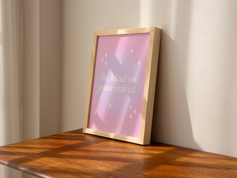 May include: A framed print with a pink and purple gradient background and white diamond shapes. The print says "be kind to your mind".