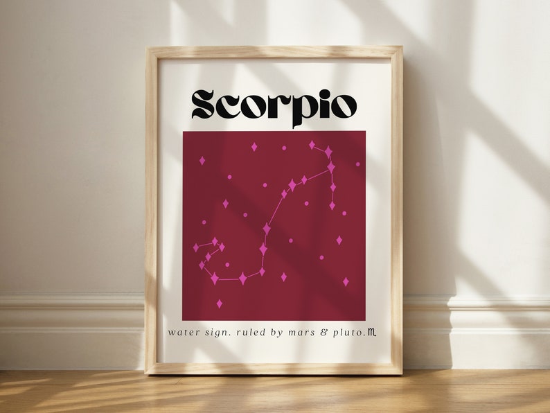 May include: A framed print with a burgundy background and the word "Scorpio" in black text at the top. The constellation Scorpio is depicted in pink with a diamond shape for each star. The text "water sign. ruled by mars & pluto.m" is at the bottom of the print.