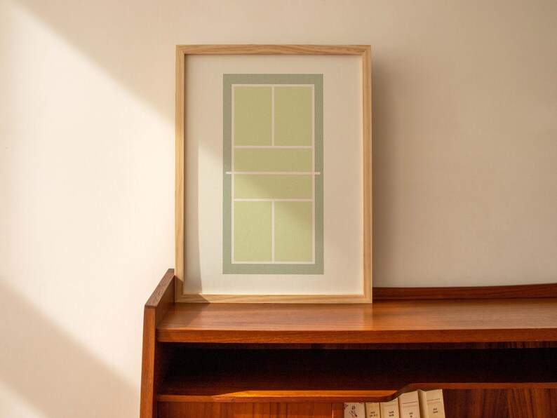 May include: A framed print of a tennis court in green and white colors. The frame is made of natural wood and the print is on white paper.