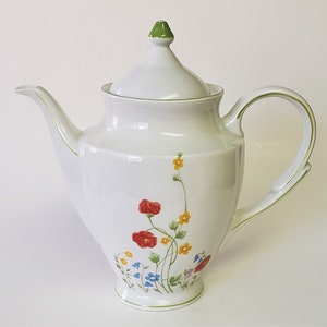May include: White porcelain teapot with a green lid and floral design. The teapot features a delicate floral pattern with red, yellow, blue, and green flowers.