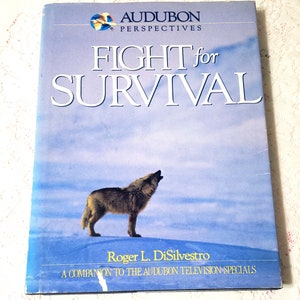 May include: A book titled "Fight for Survival" with a wolf howling on the cover. The book is part of the Audubon Perspectives series and is a companion to the Audubon television specials.