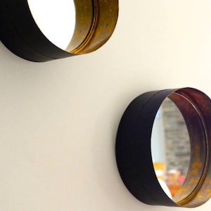 Może przedstawiać: Biały ceramiczny kubek z czarnym uchwytem i napisem "But first, coffee" czarną, odręczną czcionką. Kubek stoi na białej powierzchni.