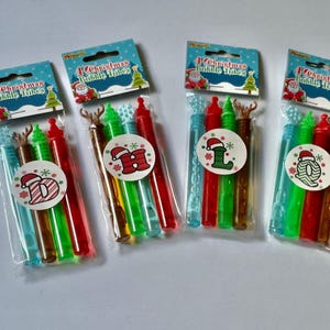 May include: Four sets of Christmas bubble wands, each set includes four wands with different colors and designs. The wands are decorated with snowflakes, reindeer, and Santa hats. The packaging says "4 Christmas Bubble Tubes".