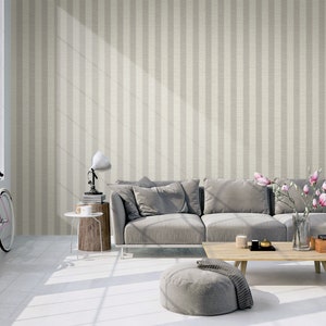K&ouml;nnte beinhalten: Tapete mit vertikalem Streifenmuster in abwechselnden Nuancen von hellem Beige und Creme. Das Design hat eine subtile, texturierte Optik, die an einen gewebten Stoff erinnert und einen neutralen Hintergrund f&uuml;r Wohnr&auml;ume schafft.