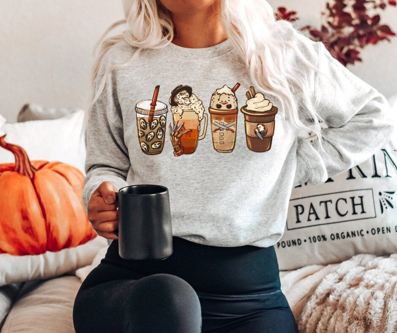 May include: A gray sweatshirt with a graphic of five different fall-themed coffee drinks. The drinks include a pumpkin spice latte, a caramel macchiato, a peppermint mocha, a gingerbread latte, and a hot chocolate. The sweatshirt is a great way to show your love for fall and coffee.