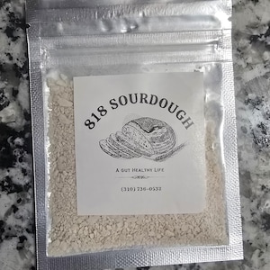 May include: A white resealable bag containing a white sourdough starter with a label that reads "818 Sourdough, A Gut Healthy Life, (310) 736-0532".