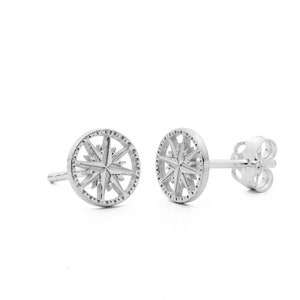 Puede incluir: Un par de pendientes de plata con forma de brújula y un diseño de estrella.