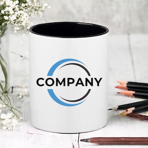 May include: White ceramic mug with a black rim and a blue and black circle logo that says "COMPANY".