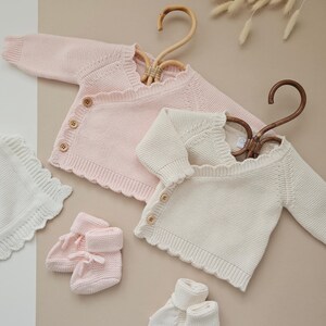 Personalised Floral Initial Knitted Baby Cardigan with embroidered monogram letter and delicate flower detail, perfect for baby girls. Ideal as a baby announcement jumper, luxury baby shower gift, or new baby present. This soft, handmade cotton sweater is a keepsake piece for newborn photos or first outfit. A thoughtful personalised gift for new parents, featuring custom initials and timeless knit design. Monogram baby sweater made with love.