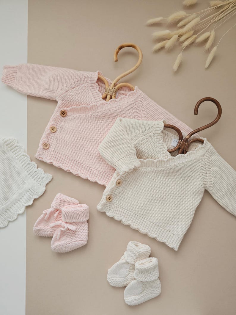 Personalised Floral Initial Knitted Baby Cardigan with embroidered monogram letter and delicate flower detail, perfect for baby girls. Ideal as a baby announcement jumper, luxury baby shower gift, or new baby present. This soft, handmade cotton sweater is a keepsake piece for newborn photos or first outfit. A thoughtful personalised gift for new parents, featuring custom initials and timeless knit design. Monogram baby sweater made with love.