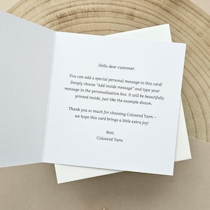 May include: An open greeting card with text, "Hello dear customer, You can add a special personal message to this card!" The card is white with a white envelope. The background is a light brown wood slice.