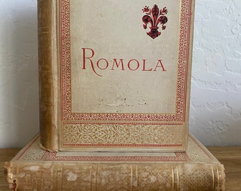 May include: A vintage hardcover book with a gold and red decorative design on the cover. The title "ROMOLA" is printed in red on the front cover.