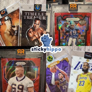 May include: A selection of encased sports and entertainment trading cards. The cards feature athletes and entertainers, including a wrestler, a football player, and a basketball player. The cards are in protective cases with labels.