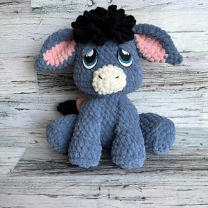 Sad version of Dylan the Donkey plush with pink ears and sparkly felt eyes from crochet pattern.
