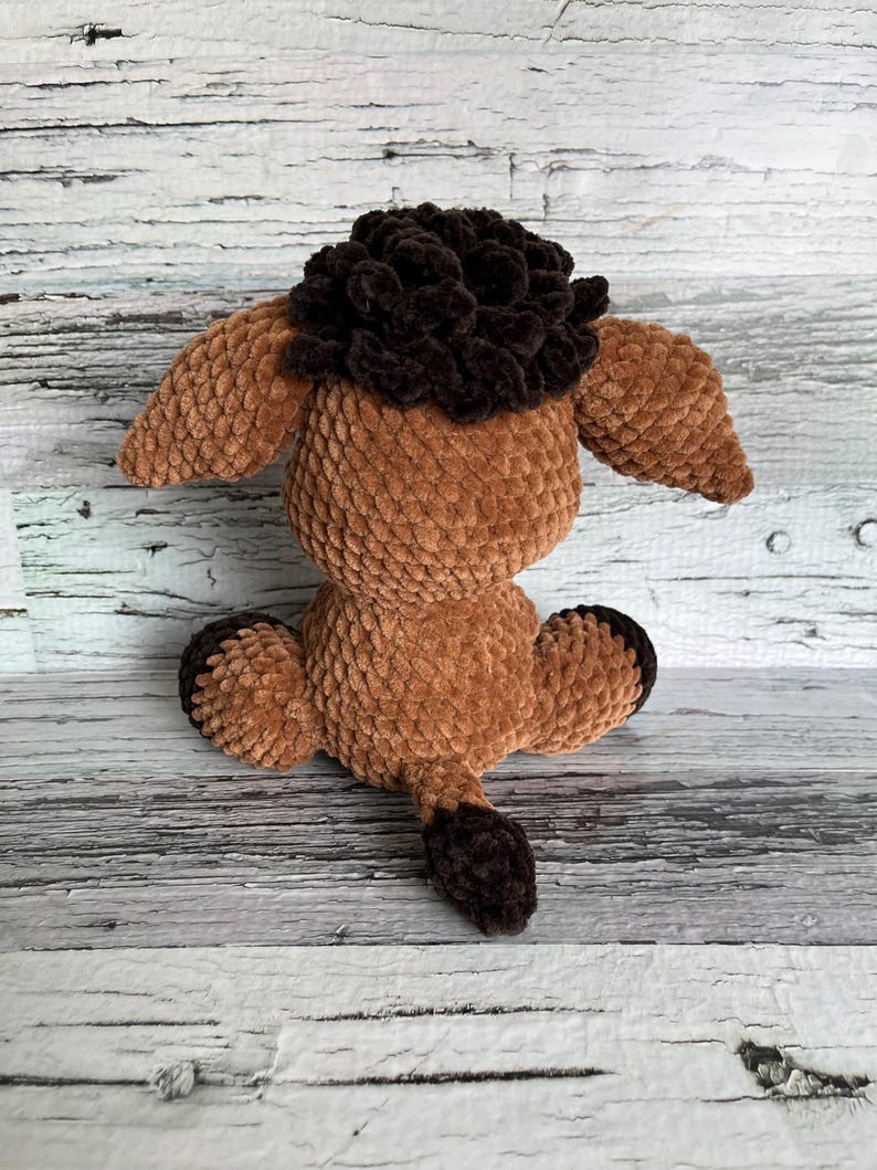 Back view of brown Dylan the Donkey plush showing its fluffy tail and soft texture.