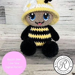 Puede incluir: Un juguete de peluche de abeja tejido a crochet que lleva un sombrero tejido a crochet amarillo y blanco. La abeja tiene rayas negras y amarillas y una cara marrón con ojos azules. El juguete está sentado sobre una superficie de madera. El texto "Buzzin Bee Low Sew Digital Pattern" está en un círculo rosa debajo del juguete. El texto "Rachel's Handmade Huggables" está en un círculo negro con una letra R blanca en el centro. El texto "Artículo digital, no artículo físico" está debajo de los círculos.