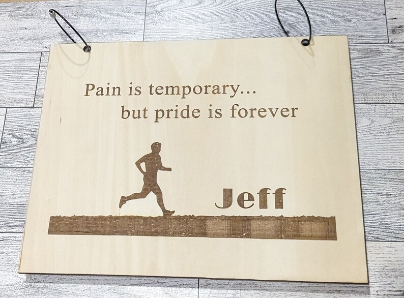 Pu&ograve; includere: Un cartello di legno con il testo "Il dolore &egrave; temporaneo... ma l'orgoglio &egrave; per sempre" e una silhouette di un corridore. Il nome "Jeff" &egrave; anche inciso sul cartello.