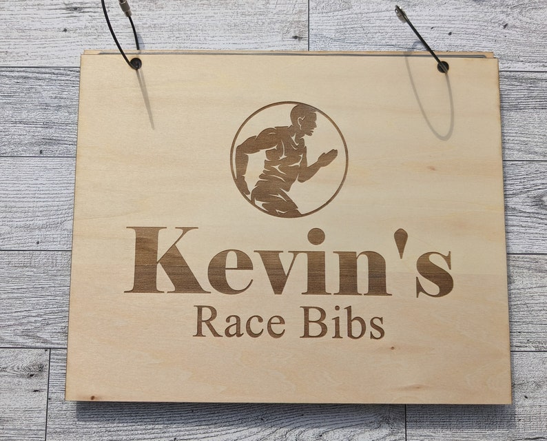 May include: Wooden sign with the text "Kevin's Race Bibs" and a silhouette of a runner in a circle.