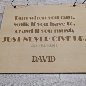Pu&ograve; includere: Un cartello di legno con la citazione "Corri quando puoi, cammina se devi, striscia se necessario: NON MOLLARE MAI." di Dean Karnazes. Il cartello &egrave; personalizzato con il nome "DAVID".