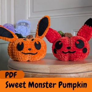 Könnte beinhalten: Zwei gehäkelte Kürbis-Plüschtiere, eines orange und eines rot, mit schwarzen Augen und einem lächelnden Mund. Die Kürbisse stehen auf einem Holztisch. Der Text "PDF Sweet Monster Pumpkin" befindet sich am unteren Rand des Bildes.