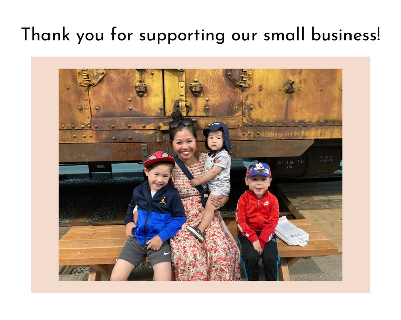 May include: A woman and three children pose in front of a rusty train car. The woman is wearing a floral dress and the children are wearing casual clothing. The children are smiling and the woman is looking at the camera.