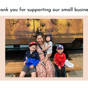May include: A woman and three children stand in front of a rusty train car. The woman is wearing a floral dress and the children are wearing casual clothing. The children are smiling and the woman is looking at the camera.