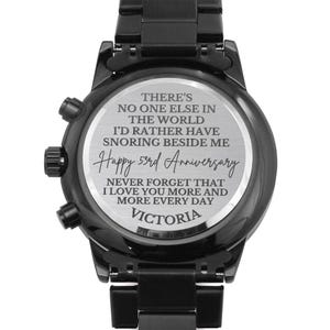 May include: Black wristwatch with a silver face and engraved message: "There's no one else in the world I'd rather have snoring beside me. Happy 53rd Anniversary. Never forget that I love you more and more every day. Victoria."