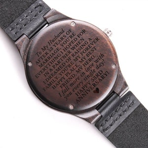 May include: A brown wooden wristwatch with a black leather band. The watch face has a black background with white text that reads "To My Husband After 53 Years of Marriage, You're Everything I Hoped For In A Partner When I Dreamed Of Raising A Family. You're My Forever Friend, My Hero. I Fall More In Love With You Every Single Day! Happy 53rd Anniversary!"