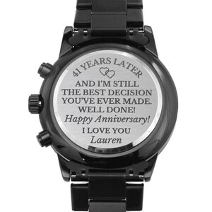 May include: Black stainless steel watch with a silver engraved message on the back. The message reads "41 Years Later And I'm Still The Best Decision You've Ever Made. Well Done! Happy Anniversary! I Love You Lauren".