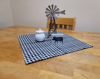 Puede incluir: Un camino de mesa a cuadros blanco y negro con un azucarero de cerámica blanca, un molino de viento de metal y un pequeño letrero de madera que dice "You had me at bacon".