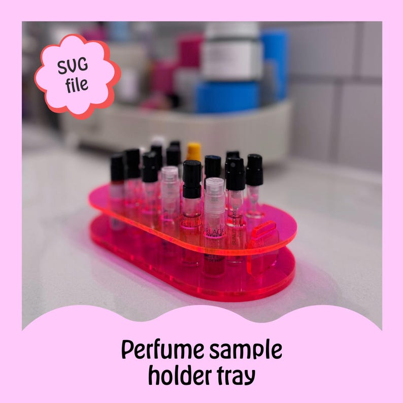 May include: A pink acrylic perfume sample holder tray with 18 slots for small perfume bottles. The tray is oval shaped and has two tiers.