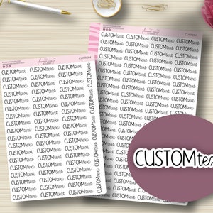 May include: Two sheets of pink and white patterned paper with the text "CUSTOMtext" repeated multiple times in black. The text is in a handwritten font. The sheets are on a wooden surface.