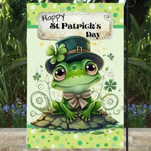 Puede incluir: Una rana verde con un sombrero de duende verde con un trébol en la parte superior. La rana está sentada en una roca con una pajarita verde. El fondo es verde con lunares blancos y tréboles. El texto "Happy St. Patrick's Day" está en un cartel sobre la rana.