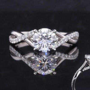 May include: A silver engagement ring with a large round diamond center stone and smaller diamonds set in a twisted band.