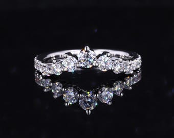 May include: A silver ring with a row of small diamonds and a larger diamond in the center, forming a crown shape.