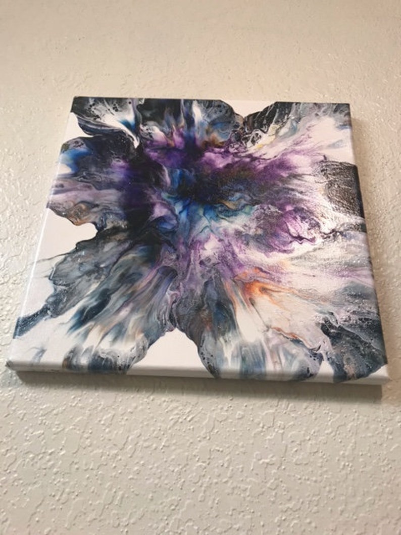 May include: Abstract painting on canvas with a white background and a large, colorful, purple, blue, and black flower-like design.
