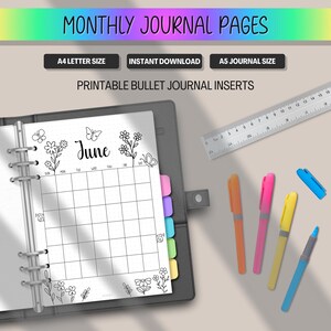 May include: A black journal open to a June monthly calendar page with floral and butterfly illustrations. The page is surrounded by colorful pens, a ruler, and the text "MONTHLY JOURNAL PAGES". The journal is A4 and A5 size.