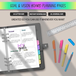Peut inclure: Un planificateur avec des pages de planification de tableau de vision et d'objectifs. Les pages sont &agrave; l'int&eacute;rieur d'un classeur gris avec des onglets color&eacute;s. L'image comprend des stylos, une r&egrave;gle et du texte qui dit "Goal & Vision Board Planning Pages".