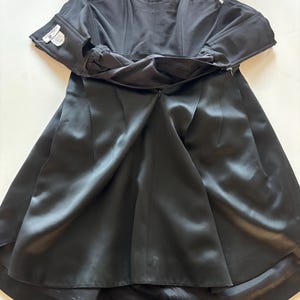 May include: A black strapless satin dress with a zipper in the back. The dress is fully lined and has a fitted bodice and a full skirt.