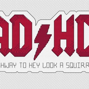 May include: Cross-stitch design featuring the text "AD-HD" in red, stylized like a rock band logo, with a lightning bolt. Below, the phrase "HIGHWAY TO HEY LOOK A SQUIRREL!" is written in a similar font, all on a white background.