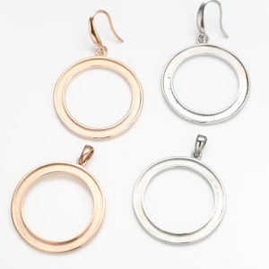 May include: Two pairs of round hoop earrings, one pair is gold and the other is silver. The earrings are simple and elegant.